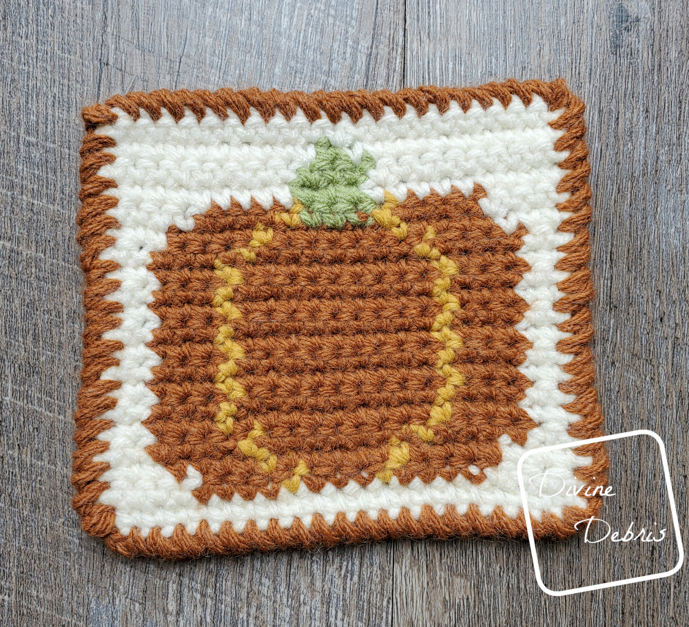 [Image description} top down view of a Fall Pumpkin Coaster on a wood grain background.