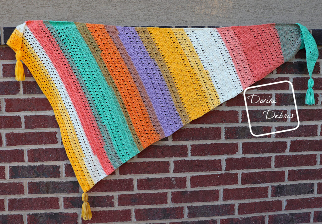 [Image description] The Brecken Shawl lays along a brick wall, extended to show all the colors and texture. 